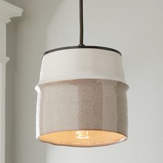 a light fixture hanging from a ceiling in a room with white walls and wood trim