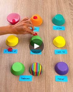 a person is playing with colorful cupcakes on the table and matching them to match their colors