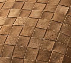 an up close view of a brown leather material with squares and lines on the surface