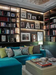 a living room filled with lots of bookshelves next to a couch and coffee table