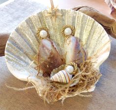 two seashells in a shell with pearls on them sitting on a wooden table