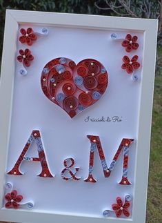 a white frame with red and silver buttons in the shape of a heart on it