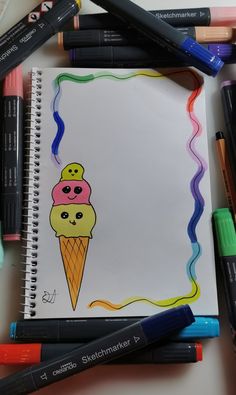 a notebook with an ice cream cone drawn on it and colored crayons next to it