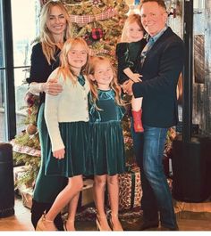 a family standing in front of a christmas tree