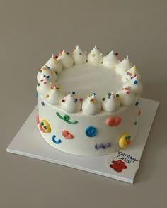 a birthday cake with white frosting and colorful sprinkles on the top