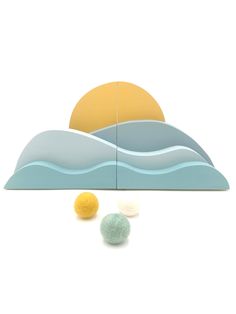 three balls are sitting in front of an image of the sun and water on a white background