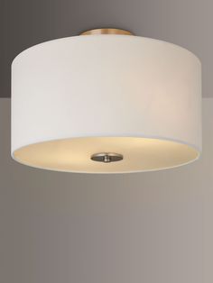 a light fixture with a white shade hanging from it's center point in a room