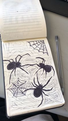 an open notebook with spider drawings on it