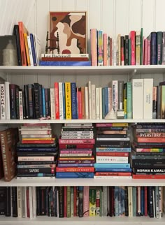 a bookshelf filled with lots of different types of books on top of white shelves