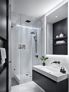 a modern bathroom with black and white decor, including a walk - in shower area