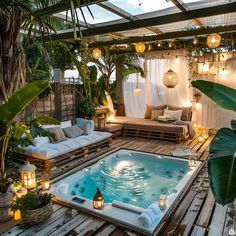 an outdoor hot tub surrounded by greenery and candles in the middle of a wooden deck