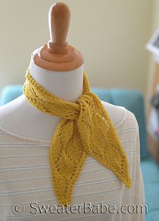 a woman wearing a yellow scarf on top of a mannequin