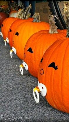 several pumpkins with faces drawn on them lined up