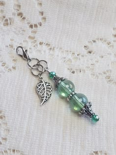 a close up of a key chain on a lace table cloth with beads and charms