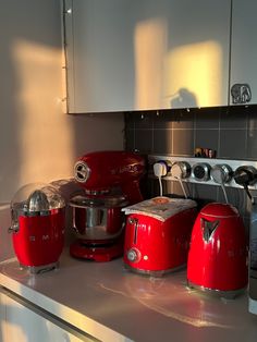 a kitchen counter with red appliances on it