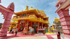 people are standing in front of a brightly colored temple