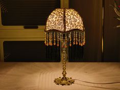 a leopard print lamp on top of a bed next to a wall mounted microwave oven