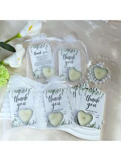 wedding favors with thank you written on them and white flowers in the backgroud