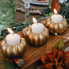 three lit candles sitting on top of a wooden table