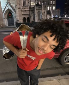 a young man is standing on the sidewalk