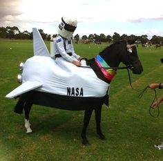 a man riding on the back of a horse wearing a nasa suit and helmet,