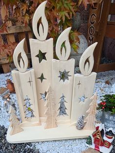 a group of wooden christmas decorations sitting on top of a pile of rocks and gravel