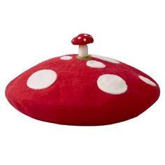 a red mushroom pillow with white dots on it