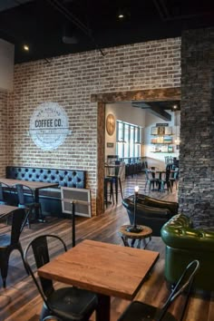 the inside of a coffee shop with tables and chairs in front of a brick wall