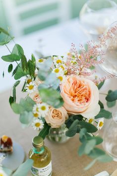 an arrangement of flowers and greenery on a table