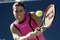 a woman hitting a tennis ball with a racquet