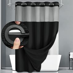 a hand holding a black and silver shower curtain