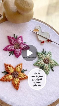 the embroidery is being worked on by someone using scissors and yarns to make flowers