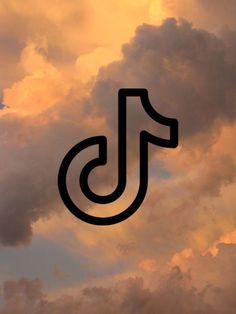 the letter j is in front of a cloudy sky with dark clouds and an orange glow