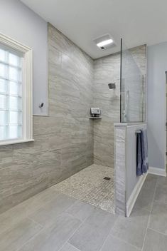 a bathroom with a walk in shower next to a window