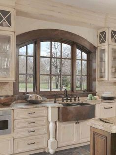 a large kitchen with white cabinets and marble counter tops