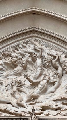 an intricately carved sculpture on the side of a building with angels and clouds above it