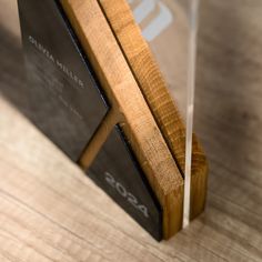 an award is placed on top of a wooden stand with clear acrylic cover