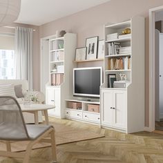 a living room filled with furniture and a flat screen tv on top of a wooden shelf