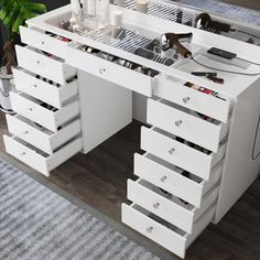 a white desk with drawers and candles on it