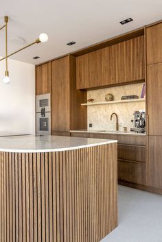 a large kitchen with wooden cabinets and marble counter tops, along with an island in the middle