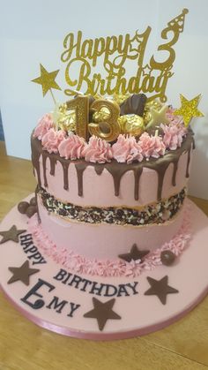 a birthday cake with pink frosting and gold stars on the top that says happy 3rd birthday