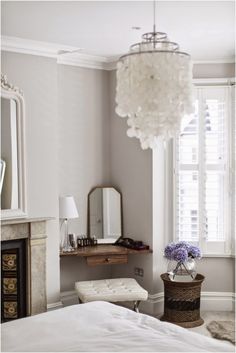 a bedroom with a bed, dresser and mirror in the corner next to a window