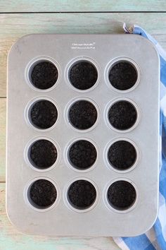 a muffin pan filled with cupcakes on top of a blue and white towel