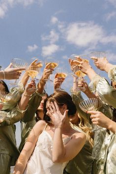 a group of bridesmaids toasting with champagne flutes in front of the camera