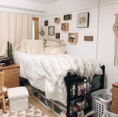 a bedroom with white bedding and lots of pictures on the wall next to it