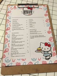 a menu with hello kitty on it sitting on top of a table