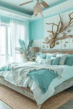 a large bed sitting in a bedroom next to a window covered in blue sheets and pillows