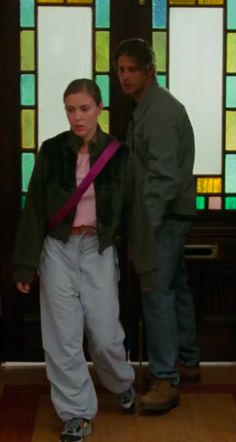 two people standing next to each other in front of stained glass windows