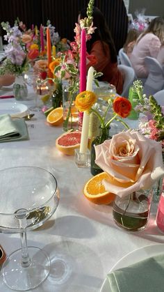 the table is set with orange slices and flowers