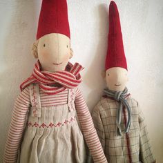 two dolls are wearing red hats and scarves